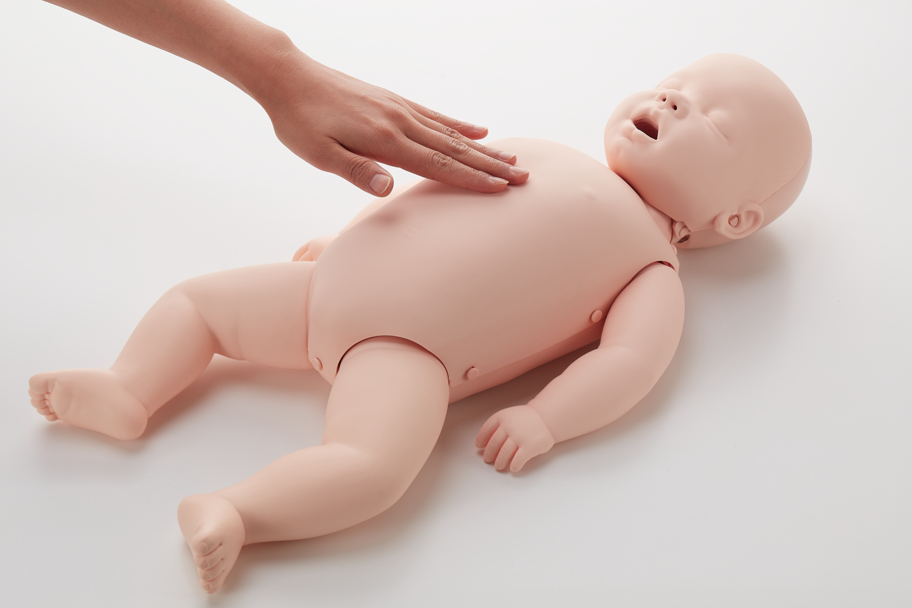 Brayden Baby illuminating CPR manikin showing hand placement on chest